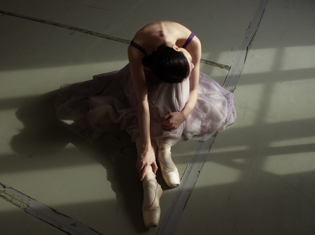 graceful ballet dancer resting on floor