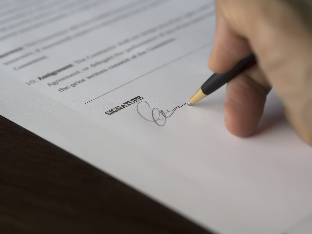 person writing a dance studio registration form with a pen on a paper