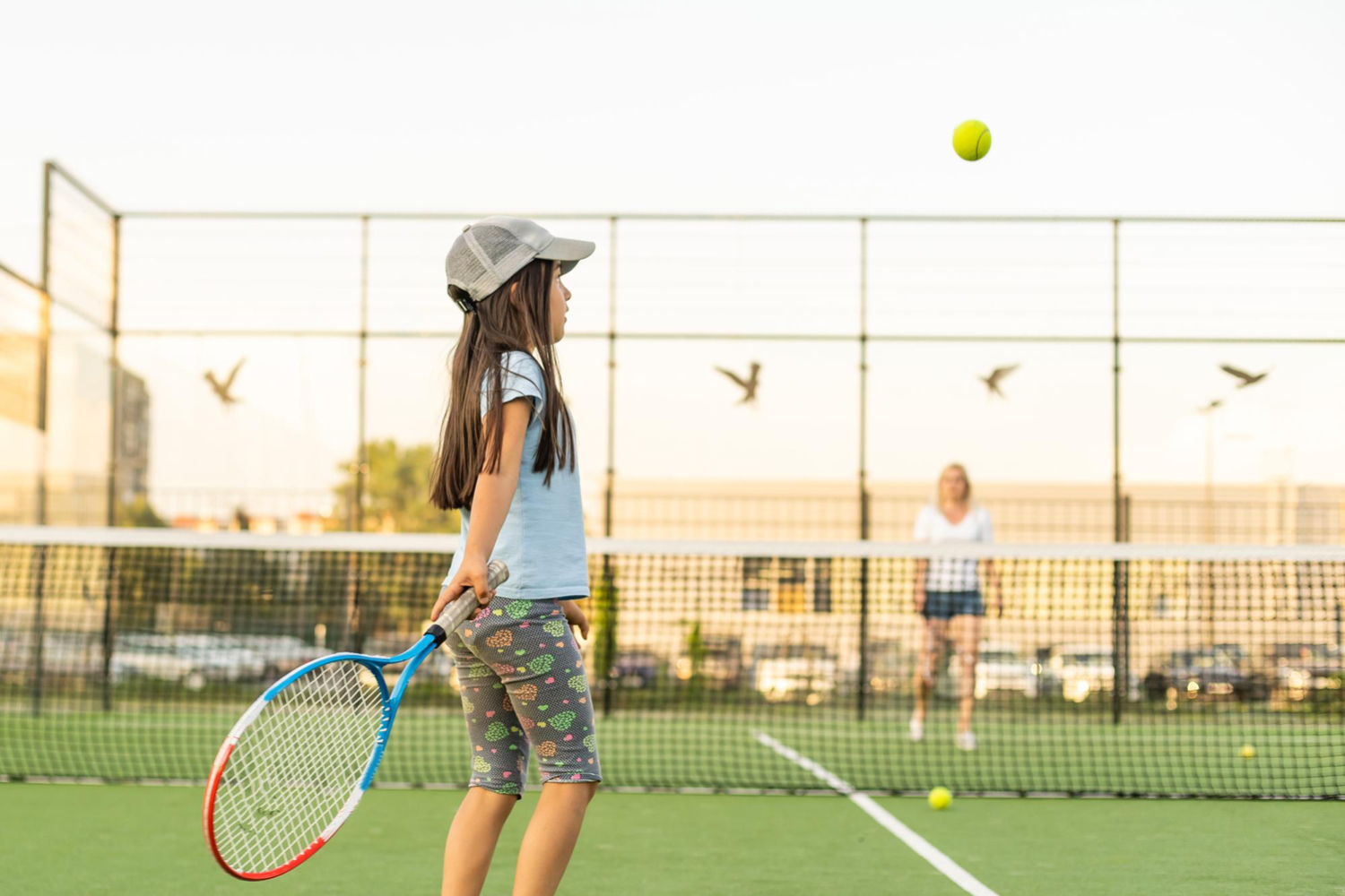 Portrait of a cute little girl playing tennis in the tennis club